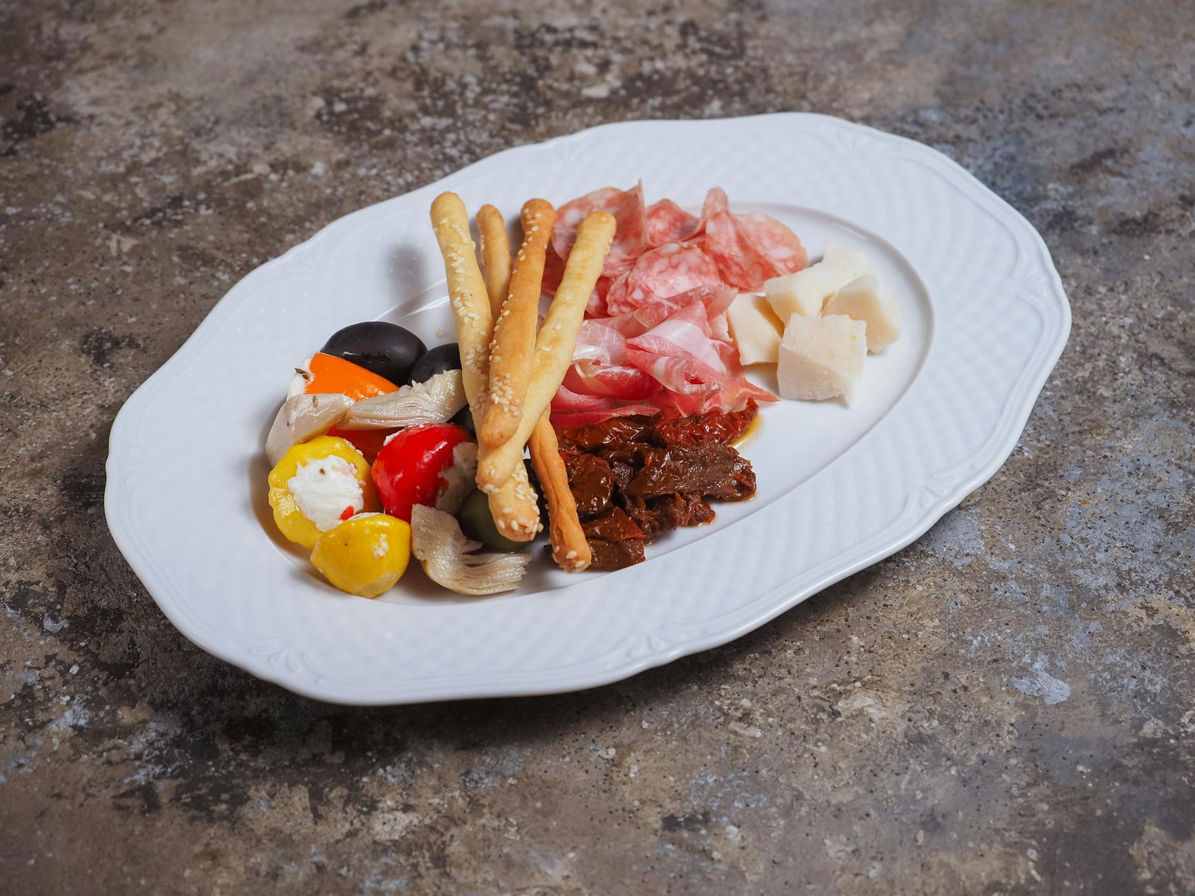 Essen mit A – Antipasti-Platte mit Oliven, eingelegtem Gemüse und Schinken