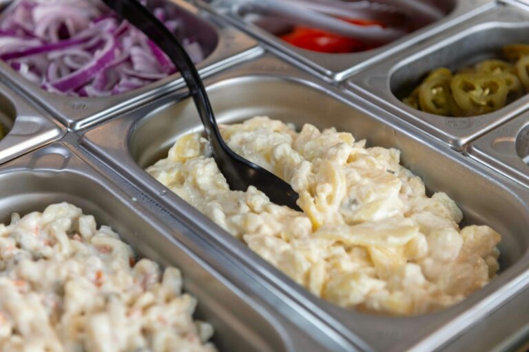 Kartoffelsalat klassisch – cremige Schüssel Kartoffelsalat auf einem Buffet