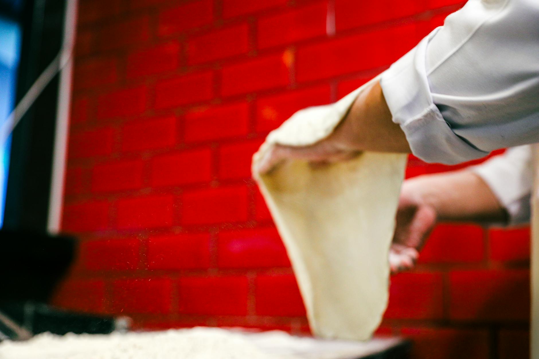 Pizzateig original italienisch – Teig wird von Hand ausgezogen